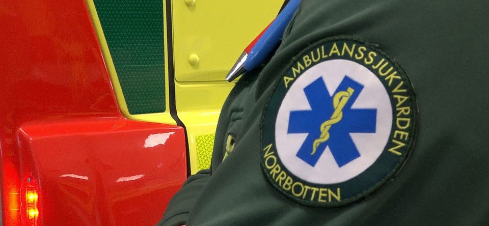 närbild på del av ambulans och en arm med logga för ambulanssjukvården i Norrbotten